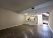 Thumbnail 15 of 33 - Pet-Friendly Apartments in Coconut Creek, FL – Waterview at Coconut Creek – empty living room with wood floors and a kitchen
