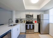 Thumbnail 1 of 33 - Coconut Creek Apartments – Waterview at Coconut Creek – kitchen with white cabinets and stainless-steel appliances