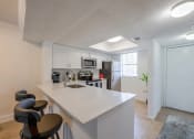 Thumbnail 6 of 33 - Pet-Friendly Apartments in Coconut Creek, FL – Waterview at Coconut Creek – kitchen with an island and stools in front of a kitchen counter top