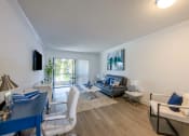 Thumbnail 8 of 33 - Coconut Creek Apartments – Waterview at Coconut Creek – living room with white walls and a sliding glass door to a patio