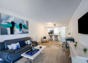 Thumbnail 7 of 33 - Apartments In Coconut Creek for Rent – Waterview at Coconut Creek – living room with a couch and a table and hardwood floors