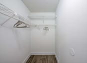 Thumbnail 11 of 33 - Coconut Creek Apartments – Waterview at Coconut Creek – empty closet with white walls and white hangers in a white room with wood
