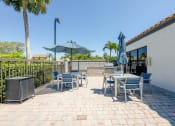 Thumbnail 20 of 33 - Coconut Creek Apartments – Waterview at Coconut Creek – patio with tables and chairs and umbrellas