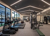 Thumbnail 42 of 67 - a gym with cardio equipment and weights on the floor of a building