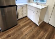 Thumbnail 4 of 8 - a small kitchen with white cabinets and a stainless steel refrigerator