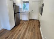 Thumbnail 3 of 8 - an empty kitchen with a refrigerator and a sink