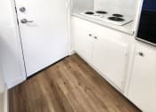 Thumbnail 5 of 8 - a small bathroom with white cabinets and a wood floor