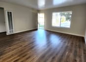 Thumbnail 2 of 8 - an empty living room with wood floors and a window