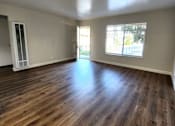 Thumbnail 5 of 10 - an empty living room with wooden floors and a window