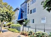 Thumbnail 1 of 20 - an apartment building with a sidewalk and trees in front of it