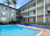 Thumbnail 18 of 20 - a large swimming pool in front of a building with palm trees