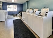 Thumbnail 20 of 20 - a laundry room with white machines and a black rug at The Chase Apartment Homes, California