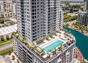 Thumbnail 2 of 18 - A tall building with a pool in the middle of it.