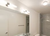 Thumbnail 2 of 15 - A bathroom with a granite countertop and a white toilet.