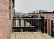Thumbnail 11 of 15 - A balcony with a black railing and wooden floor.