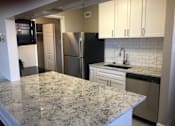 Thumbnail 3 of 36 - A kitchen with granite countertops and white cabinets. at Calvert House Apartments, Washington, DC 20008