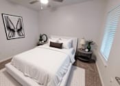 Thumbnail 7 of 63 - A bedroom with a white bed and a picture of a butterfly on the wall.