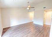Thumbnail 4 of 27 - A room with a ceiling fan and wooden flooring.