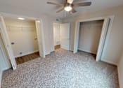 Thumbnail 31 of 42 - A room with a ceiling fan and carpeted floor.