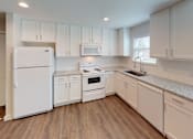 Thumbnail 40 of 42 - A kitchen with white appliances and cabinets.