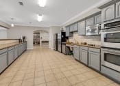 Thumbnail 25 of 26 - a large kitchen with stainless steel appliances and tiled floors