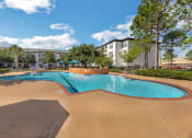 Thumbnail 5 of 26 - a swimming pool with trees and a building in the background