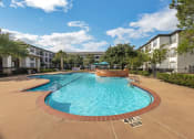 Thumbnail 4 of 26 - a swimming pool with an apartment building in the background