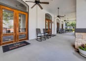 Thumbnail 14 of 26 - a long porch with rocking chairs and a ceiling fan