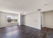 Thumbnail 3 of 24 - an empty living room with hard wood flooring and a window