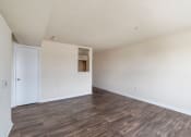 Thumbnail 5 of 24 - an empty living room with white walls and wood floors