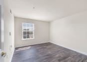 Thumbnail 4 of 24 - an empty living room with a window and wood flooring
