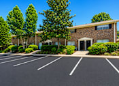Thumbnail 4 of 21 - Apartment building exterior with parking lot at Stonetree Apartments, East Point, GA