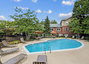 Thumbnail 14 of 26 - A pool surrounded by lounge chairs and trees.