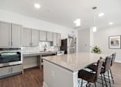 Thumbnail 2 of 36 - A kitchen with a granite countertop and stainless steel appliances.