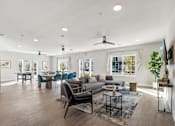 Thumbnail 28 of 36 - A spacious living room with a variety of furniture and a ceiling fan.