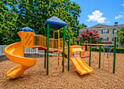 Thumbnail 2 of 18 - A playground with a yellow slide and a blue canopy.