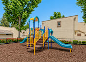 Thumbnail 9 of 12 - A playground with a blue and yellow slide.