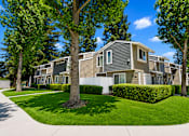Thumbnail 1 of 5 - A row of houses with green trees in front.