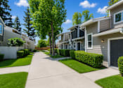 Thumbnail 3 of 5 - A row of houses with a sidewalk in between.