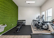 Thumbnail 9 of 33 - Fitness center with turf wall and exercise machines at Silver Ridge Apartments, Meridian, ID
