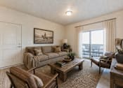 Thumbnail 17 of 33 - Living room with western artwork and patio access at Silver Ridge Apartments, Meridian, 83642