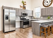 Thumbnail 13 of 33 - Contemporary kitchen with stainless steel appliances and peninsula at Silver Ridge Apartments, Idaho
