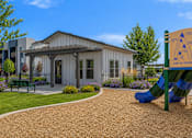 Thumbnail 6 of 33 - Playground area with clubhouse building and landscaping at Silver Ridge Apartments, Meridian