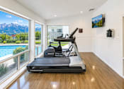 Thumbnail 9 of 17 - A treadmill in a room with a view of the mountains.