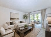 Thumbnail 14 of 21 - Living room with white sofa and patio access at Stonetree Apartments, East Point