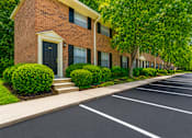 Thumbnail 5 of 21 - Brick townhome buildings with landscaped parking area at Stonetree Apartments, East Point, Georgia