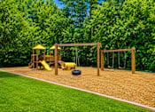 Thumbnail 7 of 21 - Outdoor playground with swings and play structure at Stonetree Apartments, Georgia, 30344