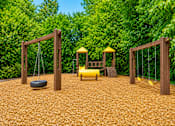 Thumbnail 6 of 21 - Playground area with swings and climbing structure at Stonetree Apartments, East Point, GA 30344