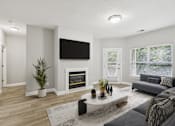 Thumbnail 1 of 26 - A modern living room with a fireplace and a flat screen TV mounted on the wall.