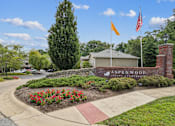 Thumbnail 25 of 26 - The image shows a well-maintained entrance to A Spenwood Apartments with a flagpole and a brick wall.